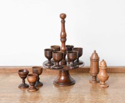 A Fruitwood Treen Egg Stand and Six Cups, early 19th century, with globular knop, turned carrying