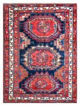 ~ Good Kazak Rug North West Iran, circa 1920 The indigo field with three Turkmen güls enclosed by