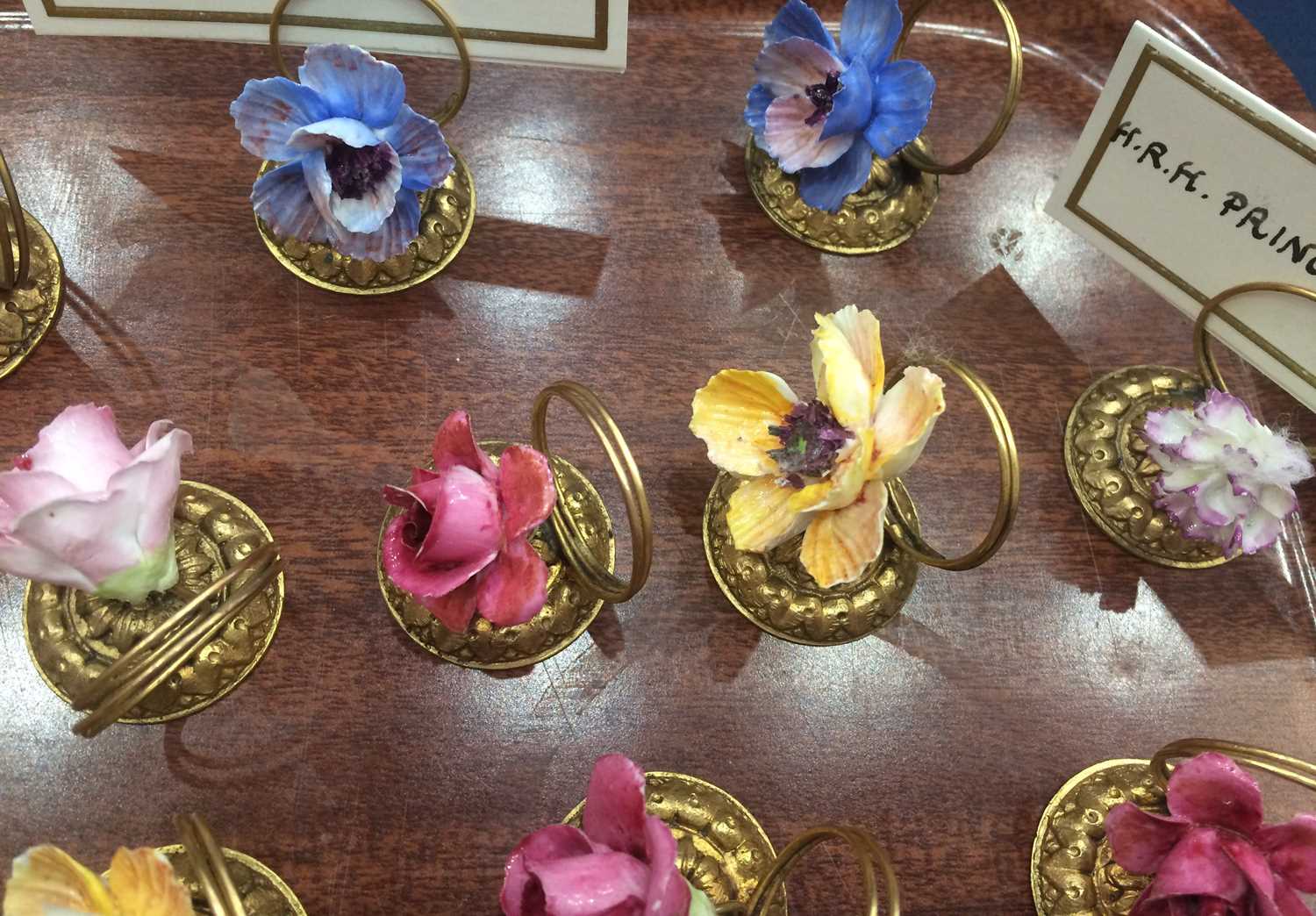 A Set of Fourteen Porcelain-Mounted Gilt Metal Place Card Holders, early 20th century, each with a - Image 5 of 5