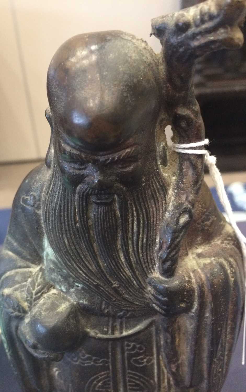 A Chinese Bronze Figure of Shoulao, in Ming style, standing wearing flowing robes holding his - Image 4 of 26