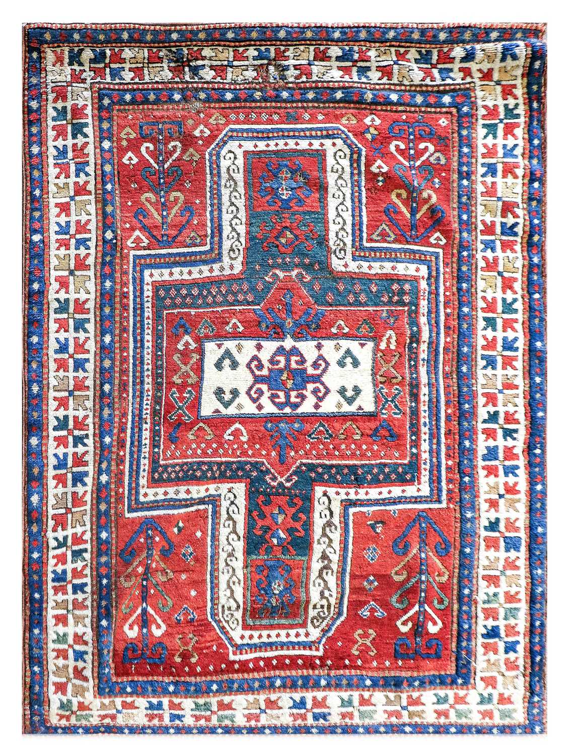 ~ Sewan Kazak Rug South Caucasus, circa 1880 The abrashed tomato red field with typical shield/