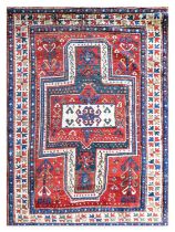 ~ Sewan Kazak Rug South Caucasus, circa 1880 The abrashed tomato red field with typical shield/