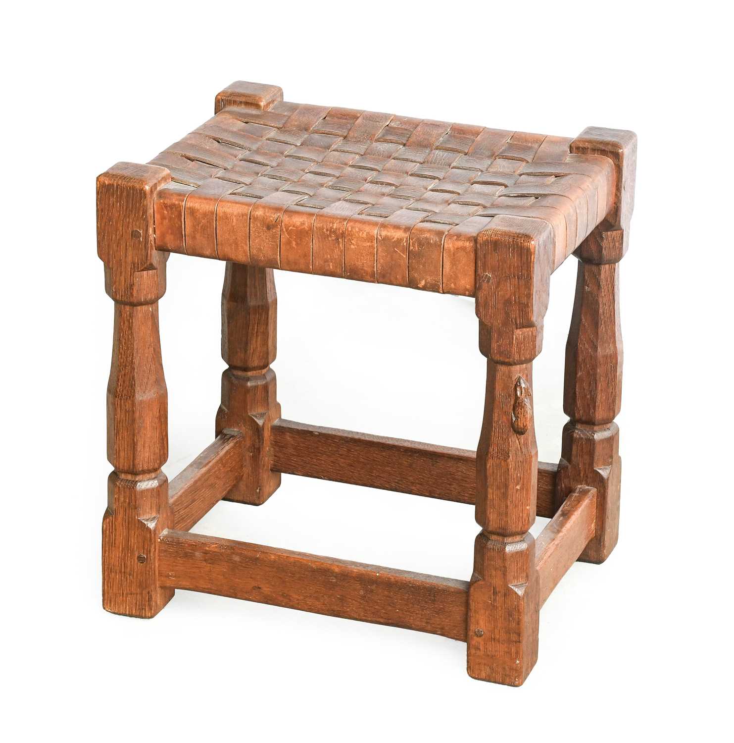 Robert Mouseman Thompson (1876-1955): An English Oak Stool, strap leather top, on four octagonal