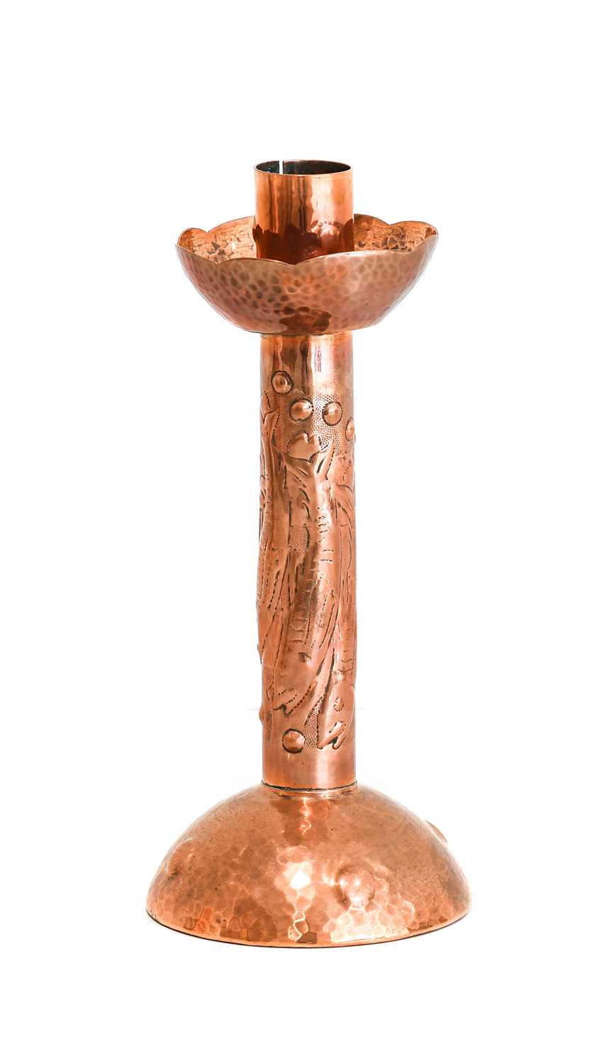 An Arts & Crafts Newlyn Copper Candlestick, repoussé decorated with three fish and bubbles,