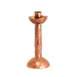 An Arts & Crafts Newlyn Copper Candlestick, repoussé decorated with three fish and bubbles,