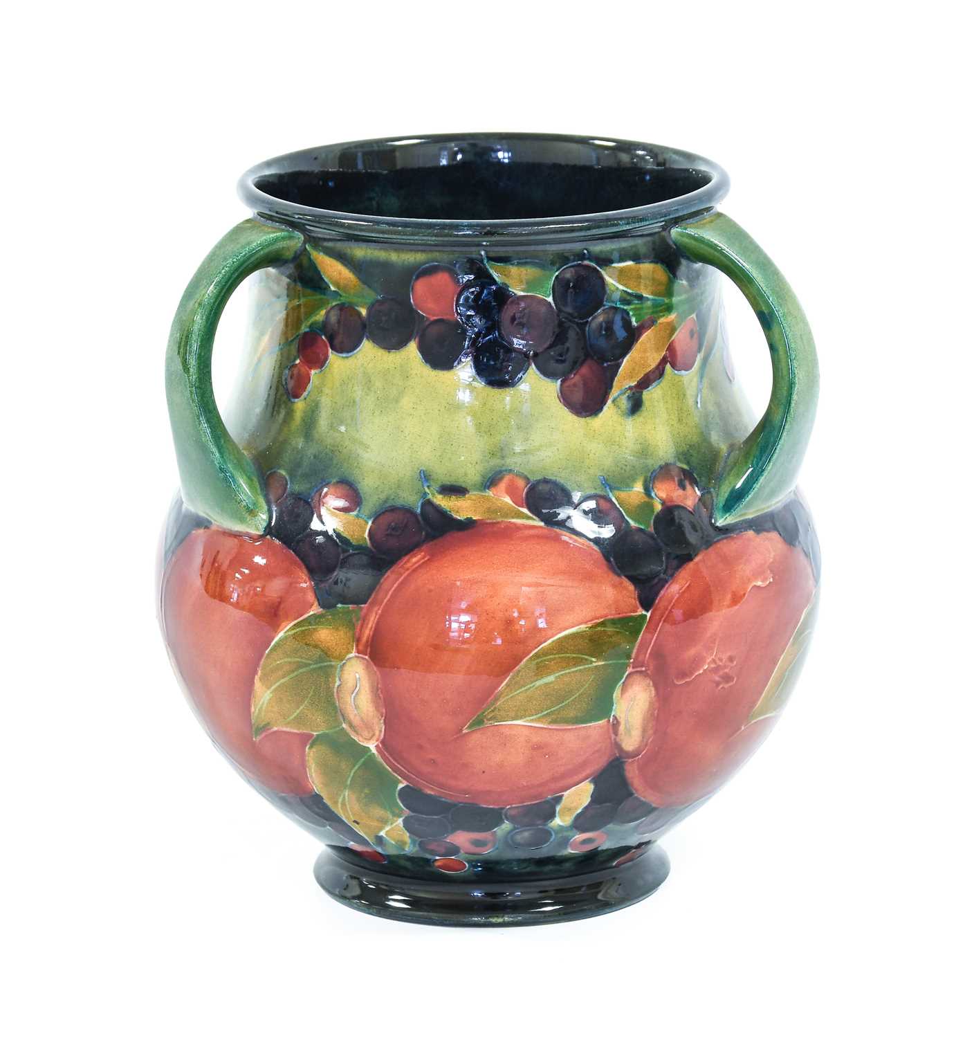 William Moorcroft (1872-1945): A Pomegranate Pattern Three-Handled Vase, on a green/blue ground,