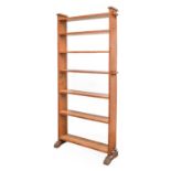 An Arts & Crafts Oak Open Pegged Bookcase, the shaped ends with pegged construction, seven fixed