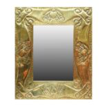 An Arts & Crafts Rectangular Brass Mirror, beaten and embossed with heart motifs and fruit, plain