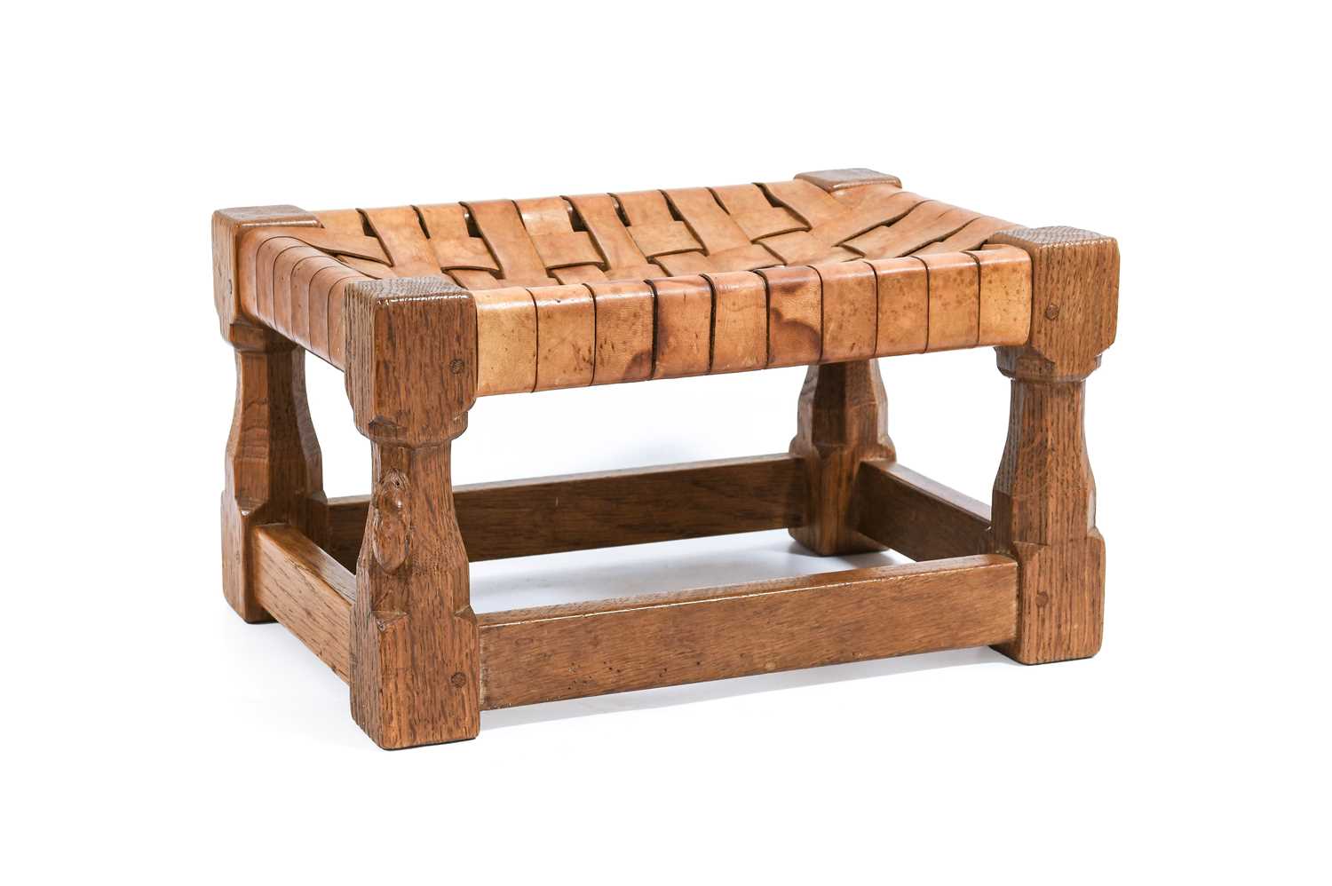 Workshop of Robert Mouseman Thompson (Kilburn): An English Oak Footstool, woven leather top, on four