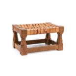 Workshop of Robert Mouseman Thompson (Kilburn): An English Oak Footstool, woven leather top, on four