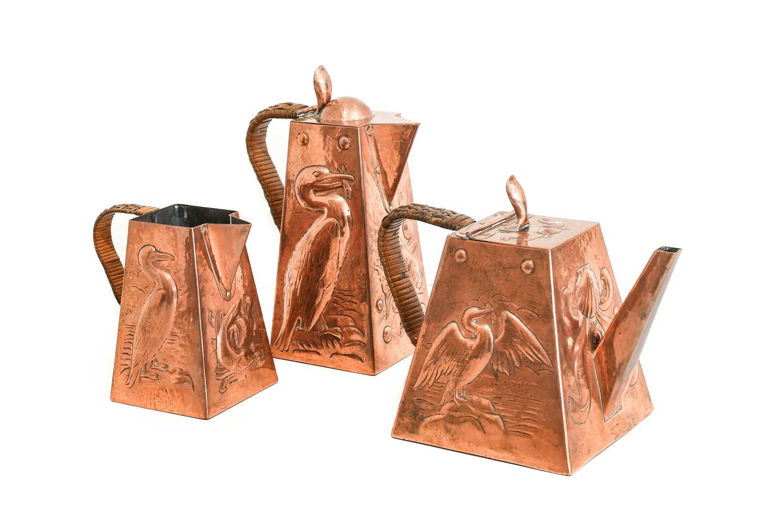 An Arts & Crafts Newlyn Copper Three Piece Teaset, comprising teapot, hot water jug and milk jug,