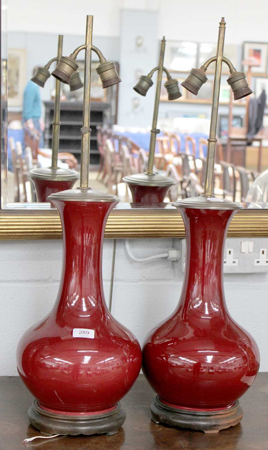 A Pair of Chinese Sang de Boeuf Vases, mounted as table lamps, each with two branches and on wood