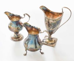Three Various George III Silver Cream-Jugs, one London, 1767, pear-shaped and on three legs, with