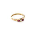 A Ruby and Diamond Three Stone Ring, the princess cut diamond flanked by square cut rubies, in