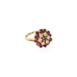 An 18 Carat Gold Ruby and Diamond Cluster Ring, the central round cut ruby within a border of