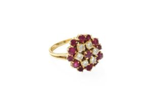 An 18 Carat Gold Ruby and Diamond Cluster Ring, the central round cut ruby within a border of
