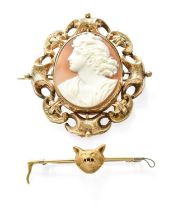 A Fox Mask Stock Pin, stamped ‘15CT’, length 5.7cm; and A Cameo Brooch, the shell cameo within a