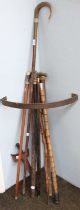 A Javanese Kris, with carved wooden handle and sheath; together with various walking canes,