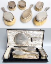 A Collection of Silver-Backed Dressing-Table Items, comprising a cased five-piece set with engine-