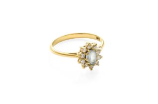 An 18 Carat Gold Aquamarine and Diamond Cluster Ring, the oval cut aquamarine within a border of