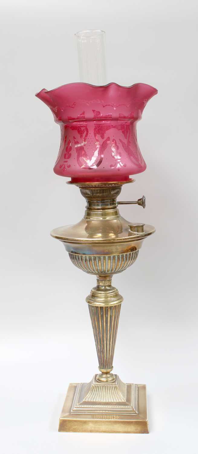 A Victorian Brass Based Oil Lamp, with etched cranberry glass shade and on fluted pedestal Shade