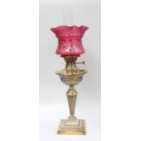 A Victorian Brass Based Oil Lamp, with etched cranberry glass shade and on fluted pedestal Shade