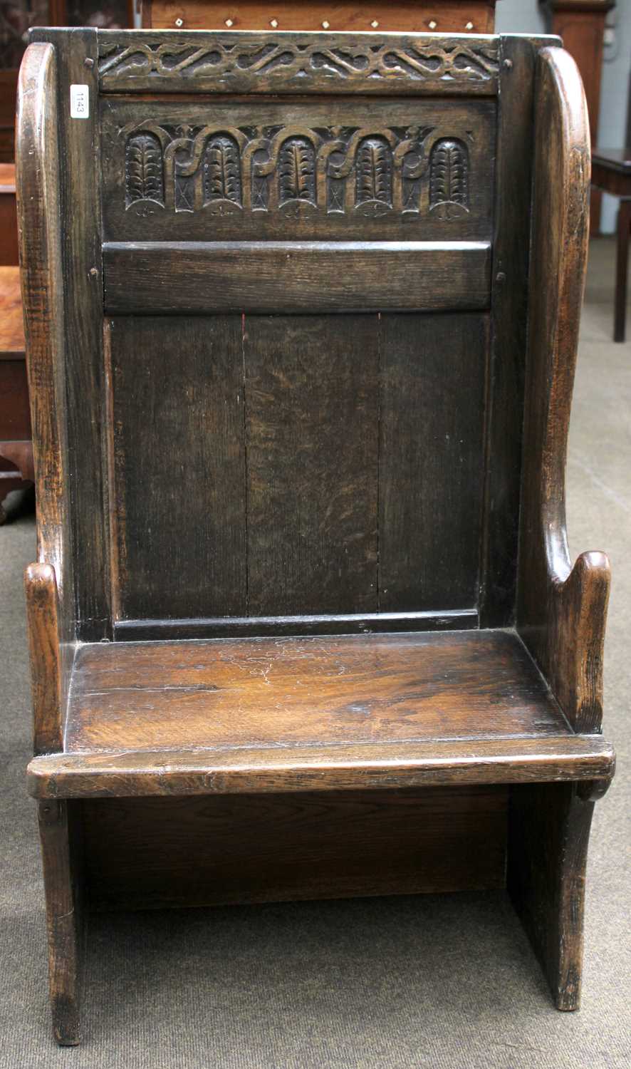 A 17th Century Style Carved Oak Single Seat Settle, of pegged construction and with panelled back