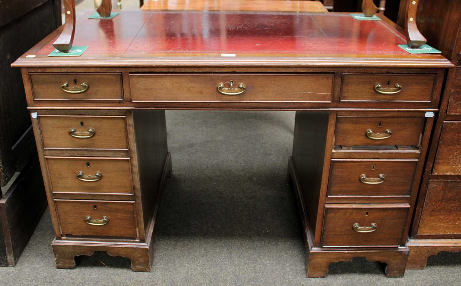 An Edwardian Mahogany Twin Pedestal Desk, with tooled red leather inset over an arrangement of