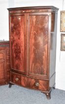 An Edwardian Mahogany Bow Fronted Wardrobe, with Greek key moulded cornice and fitted with a base
