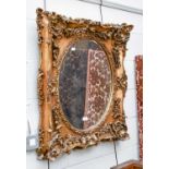 A Reproduction Gilt Framed Wall Mirror, with bevelled oval plate, ornamented with blossom and