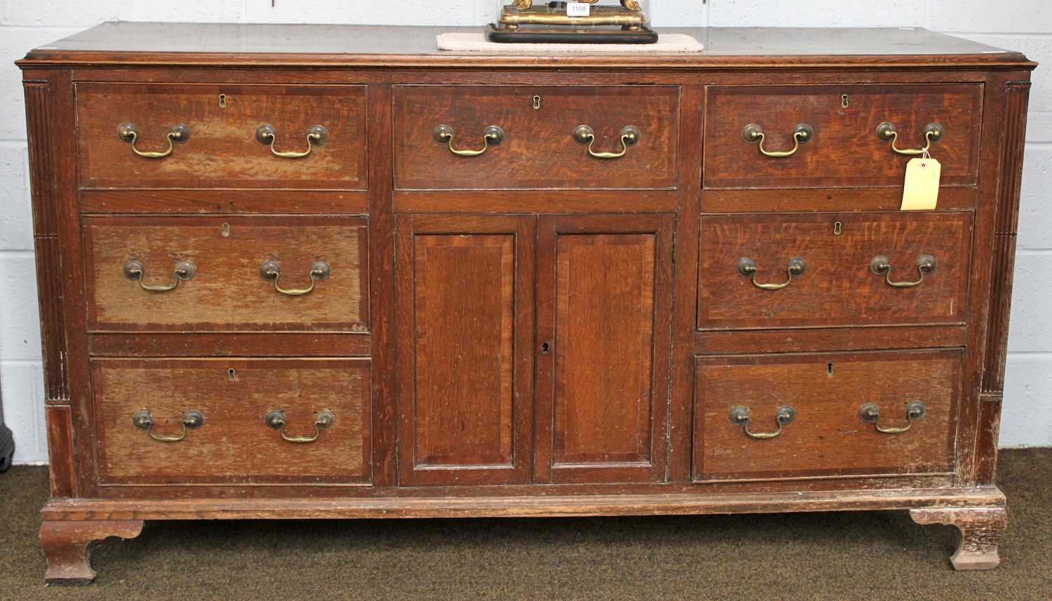 An 18th Century Oak Dresser Base, the moulded rectangular top over an arrangement of seven drawers