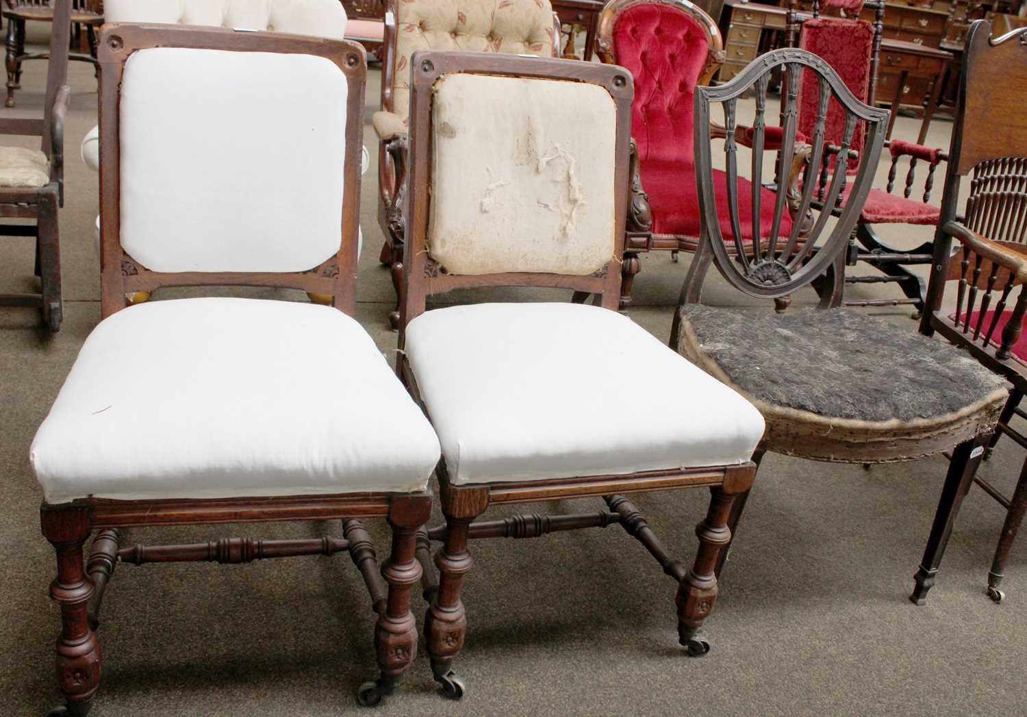 A Pair of Holland & Sons Carved Oak Side Chairs, part upholstered on turned supports and