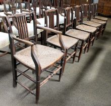 A Set of Seven Early 19th Century Rail Back Chairs, with rush seats, including one carver.