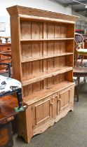 A Pine Open Bookcase, with four shelves and cupboard below, 132cm by 27cm by 185cm