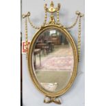 An Early 20th century Adam Revival Gilt and Gesso Wall Mirror, of oval form with elaborate urn