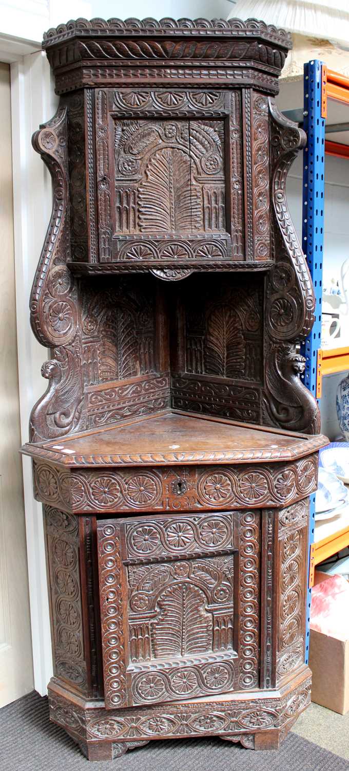 A 17th Century Style Heavily Carved Oak Full-Height Corner Cupboard, some early timbers, the upper