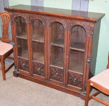 A Victorian Carved Mahogany Glaze Fronted Bookcase, with arch top doors, 131cm by 35cm by 110cm