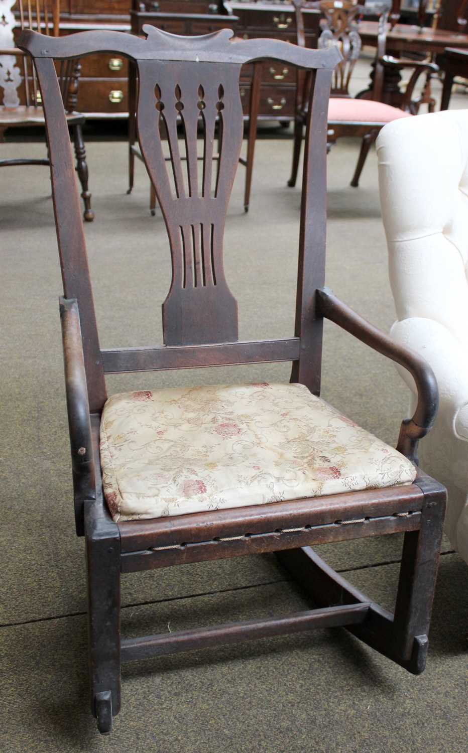 A George III Mahogany Rocking Armchair, with yoke shaped cresting rail and pierced splat