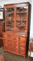 A Regency Style Mahogany Secretaire Bookcase, with strung inlay, satinwood fitted interior and splay