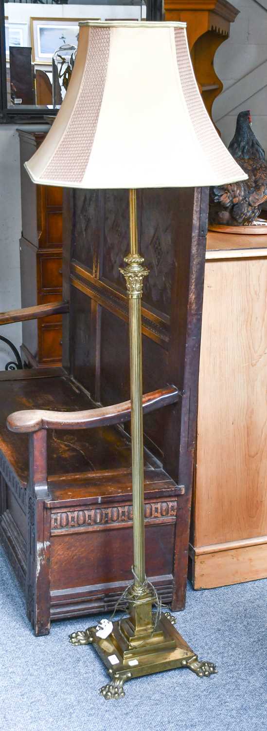 A Brass Columnar Adjustable Standard Lamp with Corinthian cap and reeded support, on claw feet