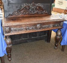 A 19th Century Oak Gothic Revival Buffet, with heavily carved scrollwork and foliate back