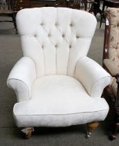 A Modern Button Backed Upholstered Armchair, turned supports and brass castors