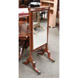 Mahogany Cheval Mirror, the turned frame with scrolling supports and brass capped castors, 64cm by
