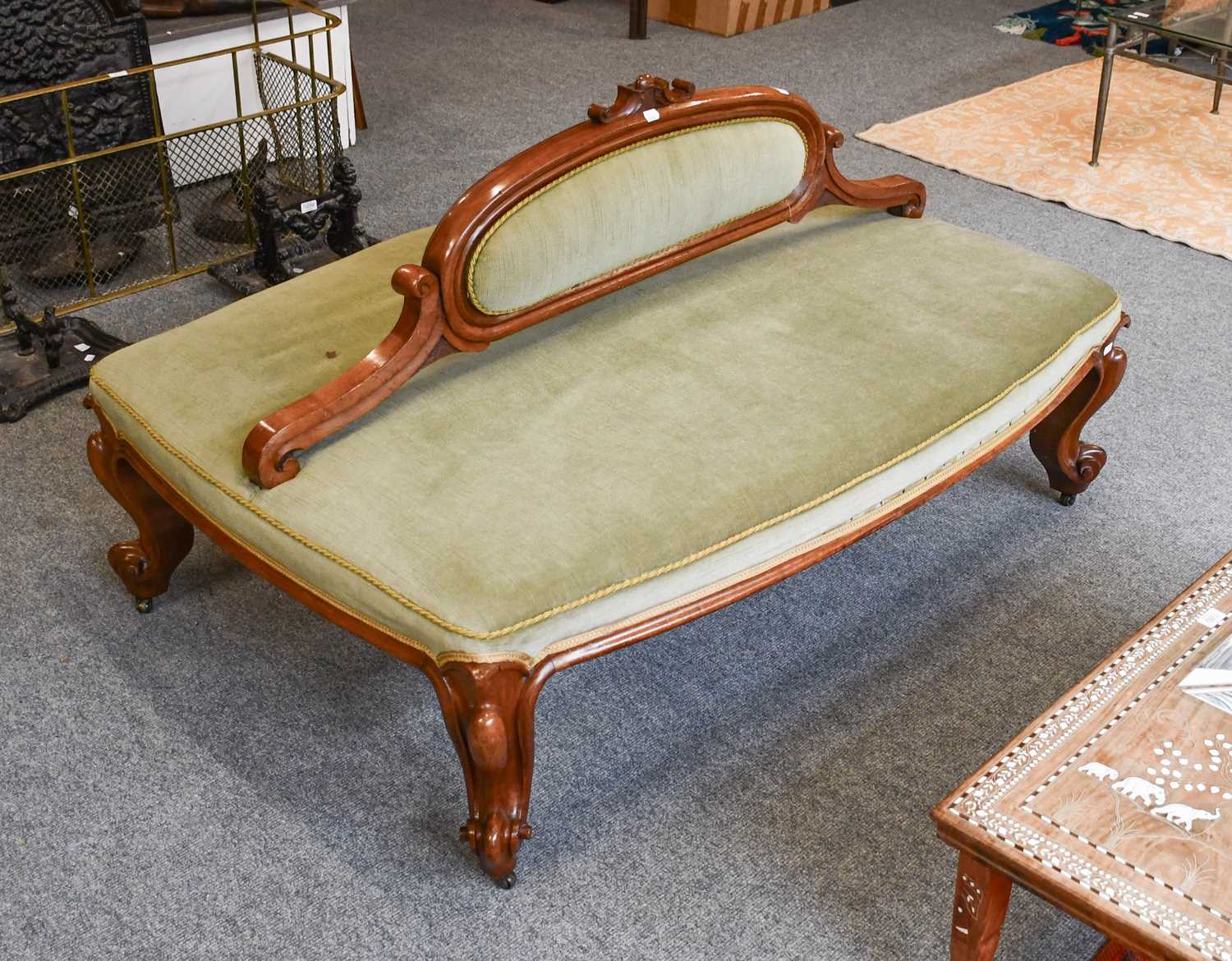 A Victorian Walnut Conversation Settee, upholstered in green velvet, 140cm by 90cm by 80cm