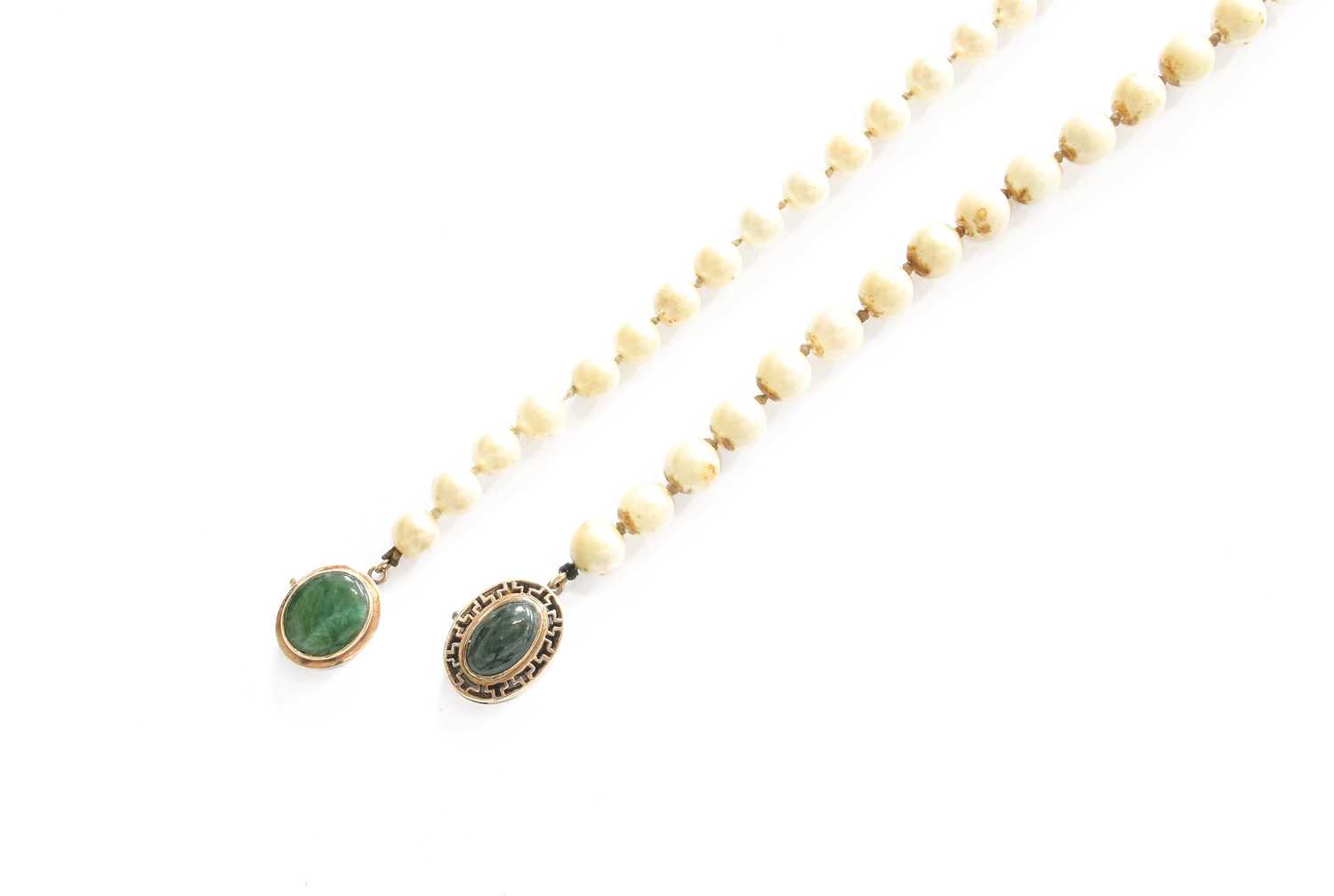 A Cultured Pearl Necklace, the clasp set centrally with an oval nephrite within a Greek key