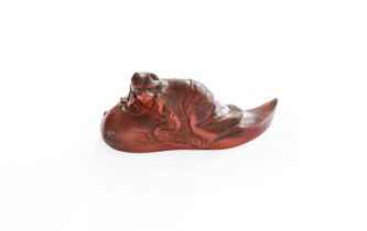 A Japanese Carved Amber Netsuke, late Meiji, formed as a cat upon a giant carp, signed