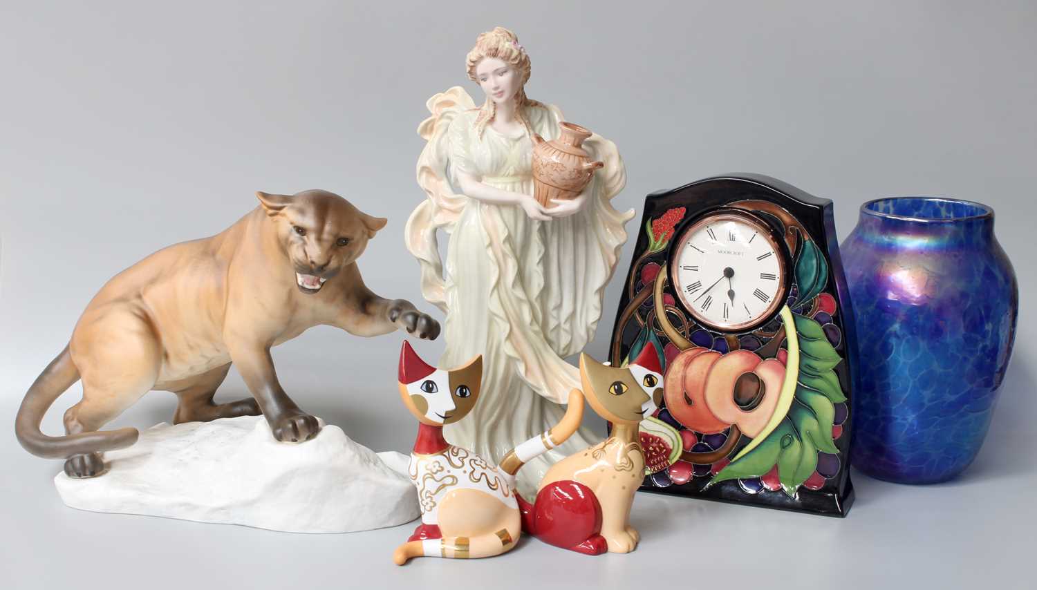 A Modern Moorcroft Mantle Timepiece, in the Queen's Choice pattern, a Beswick puma on rock, a blue
