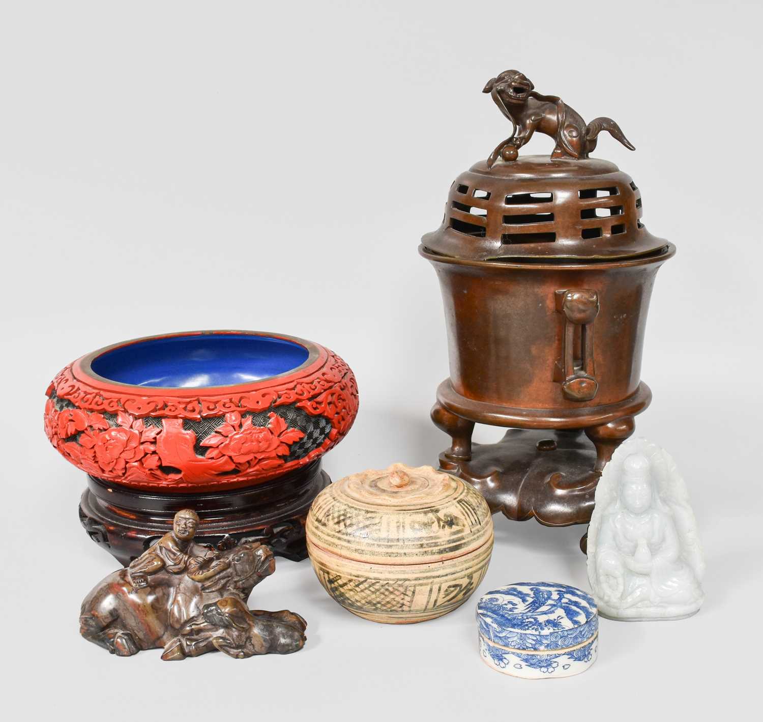 A Group of Asian Art, including a Chinese celadon jade carving of Guanyin seated, a carved soapstone