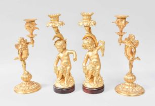 A Pair of 20th Centrury Gilt Metal Figural Candlesticks, in the form of winged putti, 24.5cm high