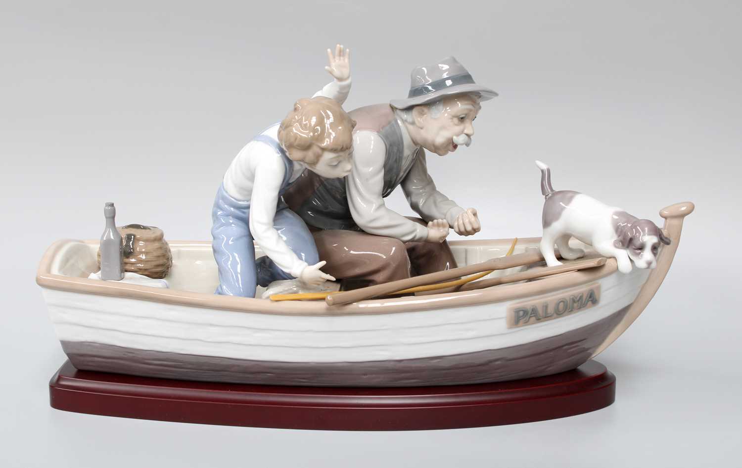 A Large Lladro Figure "Paloma", as a man, boy and dog in a rowing boat, on a wood plinth, 40cm long